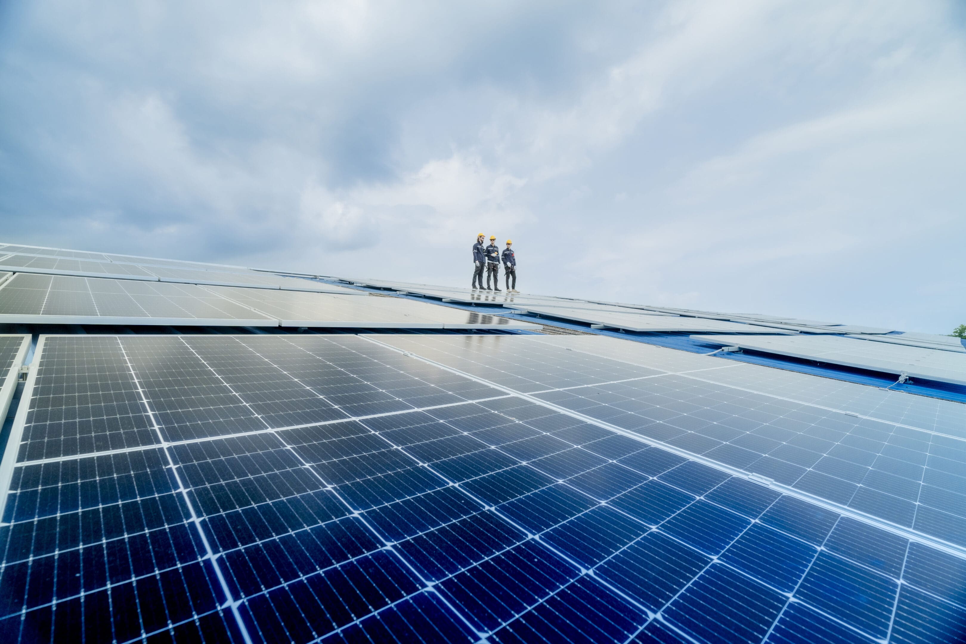 engineer man inspects construction of solar cell panel or photovoltaic cell by electronic device. Industrial Renewable energy of green power. factory worker working on tower roof.